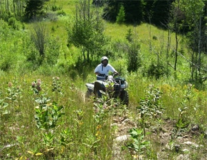 Person riding an ATV up a hill on a trail